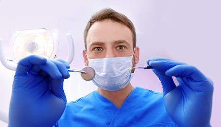 Dentist with mirror and periodontal explorer in clinicの写真素材
