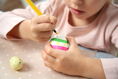 Little girl decorating Easter eggの写真素材