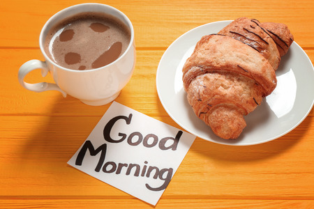Note with written phrase GOOD MORNING and tasty breakfast on tableの写真素材