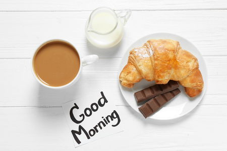 Note with written phrase GOOD MORNING and tasty breakfast on tableの写真素材