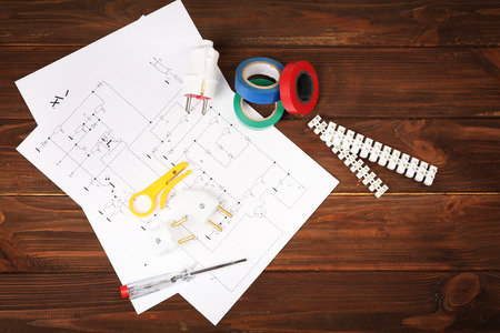 Electrician tools and schemes on wooden background