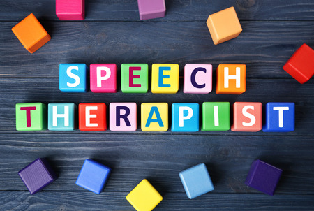 Colourful cubes with text SPEECH THERAPIST on blue wooden backgroundの写真素材