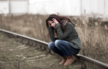 Depressed young woman on railroadsの写真素材