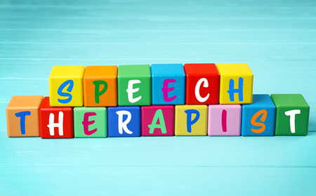 Speech therapy concept. Colourful cubes on blue wooden backgroundの写真素材