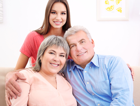 Young woman with middle aged parents on sofa in the room