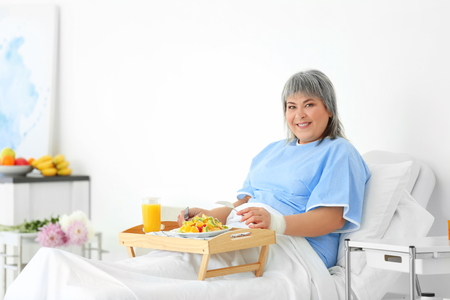 Senior woman having healthy dinner in hospitalの写真素材