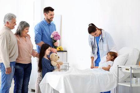 Family visiting little girl in hospitalの写真素材