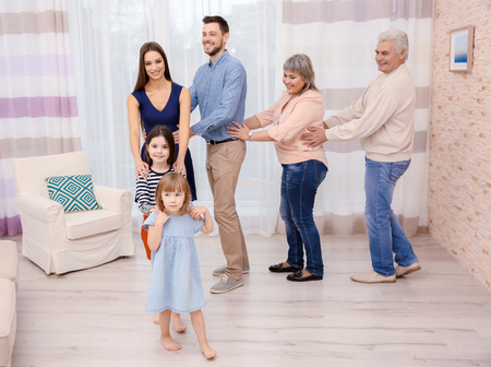 Happy big family dancing in the room