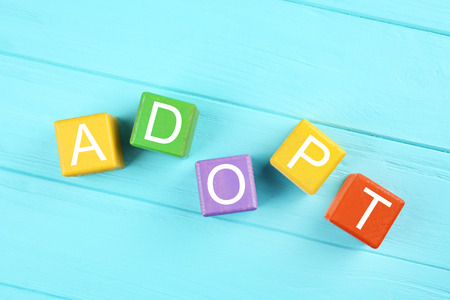 Colorful cubes with word ADOPT on wooden backgroundの写真素材