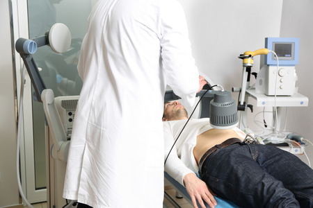 Inductive shortwave diathermy for young man in modern clinicの写真素材