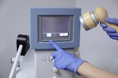 Hands of doctor adjusting  ultrasound machine in clinicの写真素材