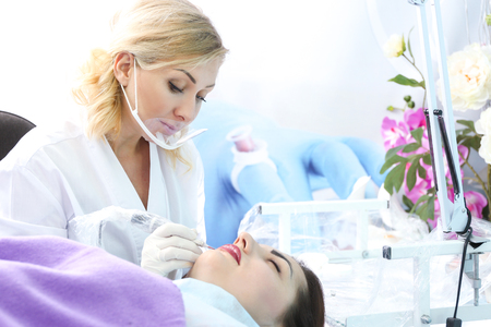 Specialist making permanent makeup in cosmetology salonの写真素材
