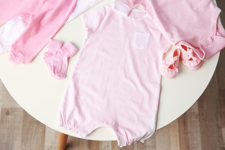 Set of baby clothes on light tableの写真素材