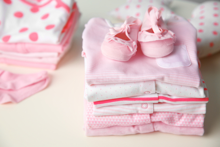Set of baby clothes on light tableの写真素材
