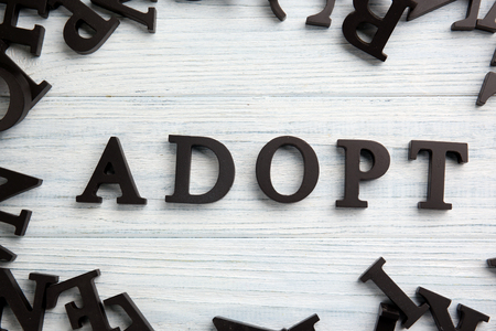 Word ADOPT on light wooden backgroundの写真素材
