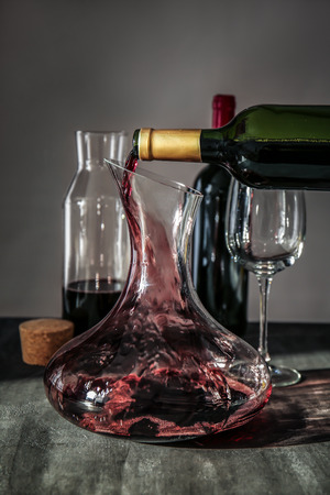 Pouring wine in carafe on table