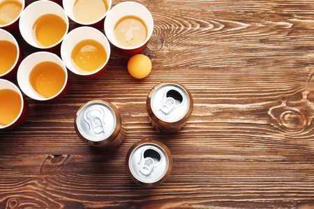 Plastic beer pong cups and cans on wooden table, top viewの写真素材
