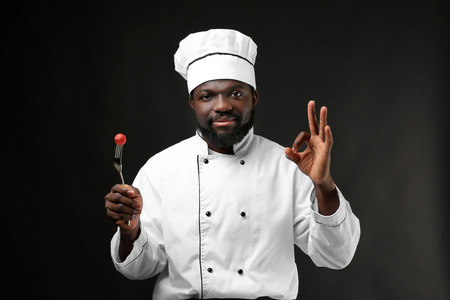 African American chef in uniform on dark backgroundの写真素材