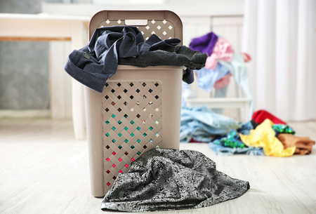 Pile of clothes in plastic laundry basket indoorsの写真素材