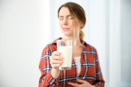 Young woman with milk allergy holding glass in handの写真素材