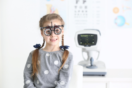 Cute little girl with trial frame in ophthalmologist's officeの写真素材