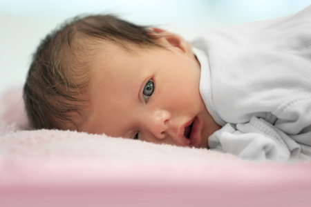 Cute funny baby lying on pile of soft towelsの写真素材