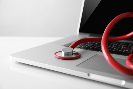 Modern laptop and stethoscope on white backgroundの写真素材
