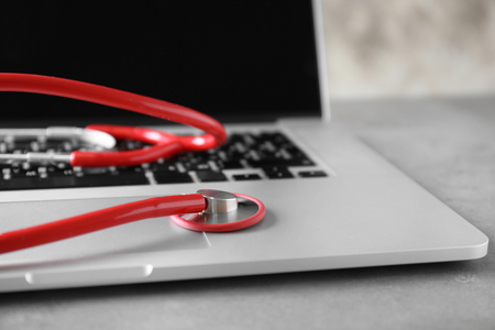 Modern laptop and stethoscope on tableの写真素材