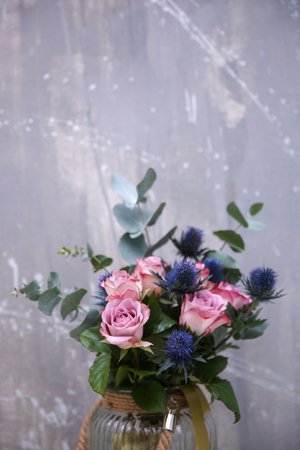 Glass vase with beautiful bouquet on color backgroundの写真素材