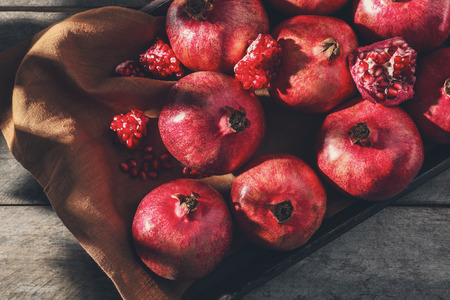 Wooden tray with pomegranates on tableの写真素材