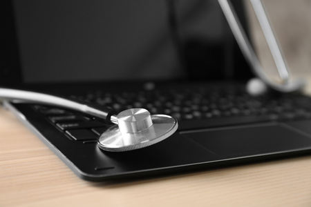 Modern laptop and stethoscope on tableの写真素材