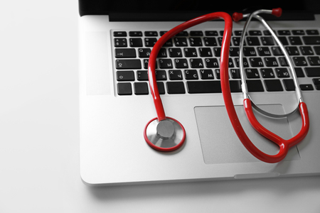 Modern laptop and stethoscope on white backgroundの写真素材