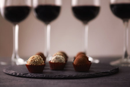 Delicious chocolate truffles and red wine on grey backgroundの写真素材