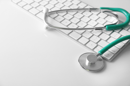 Modern wireless keyboard and stethoscope on white backgroundの写真素材