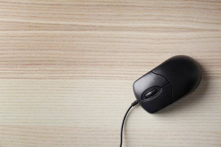 Wired black mouse on light wooden tableの写真素材