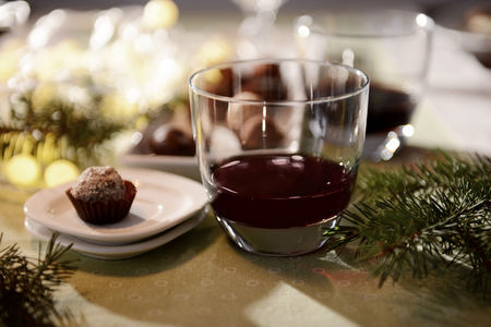 Glass of wine and chocolate candy on decorated table closeupの写真素材
