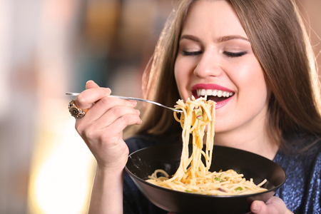 Young woman eating pasta, closeupの写真素材