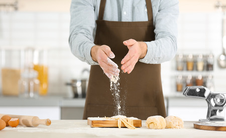 Man preparing pasta on kitchen table
