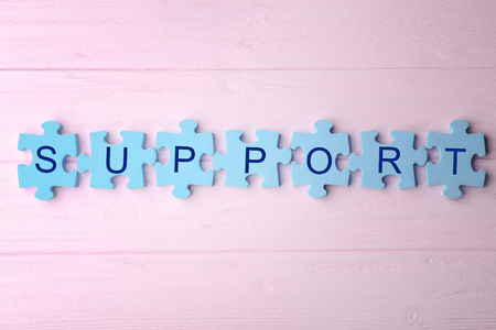 Word SUPPORT made of puzzle pieces on wooden backgroundの写真素材