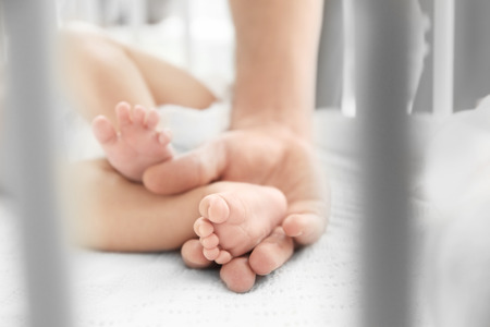 Little baby feet in mother's handsの写真素材