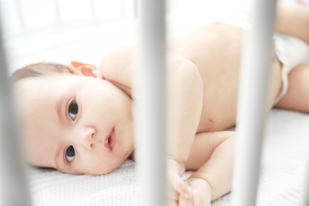 Cute little baby lying in bedの写真素材