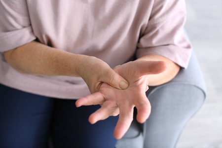 Elderly woman suffering from pain in hand, closeupの写真素材