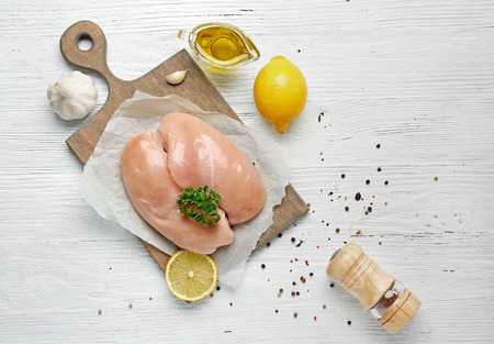 Raw chicken meat with spices on wooden backgroundの写真素材