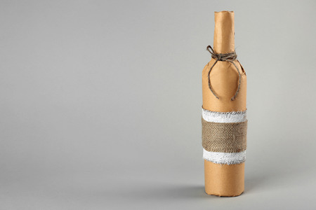 St. Valentine's Day concept. Wine bottle in gift wrap on light backgroundの写真素材