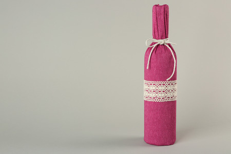 St. Valentine's Day concept. Wine bottle in gift wrap on light backgroundの写真素材