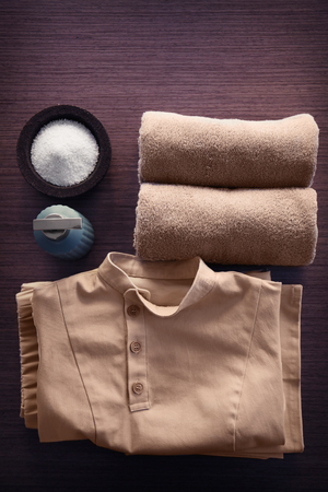Spa uniform and supplies of masseur on wooden backgroundの写真素材