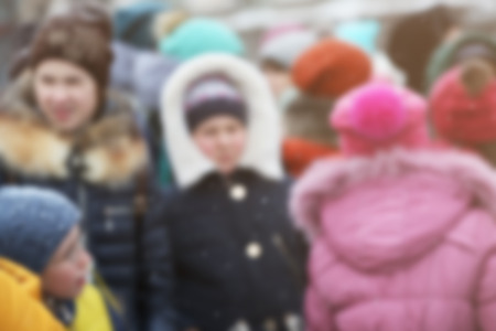 Crowd of people in warm clothes outdoors on winter day, blurred viewの写真素材