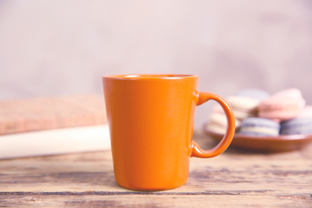 Orange cup and cookies on wooden tableの写真素材