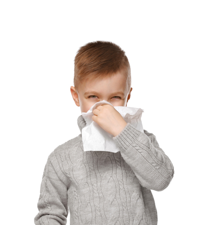 Cute little boy using tissue to blow his nose on white backgroundの写真素材