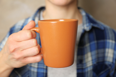 Blank color cup in hand, closeupの写真素材